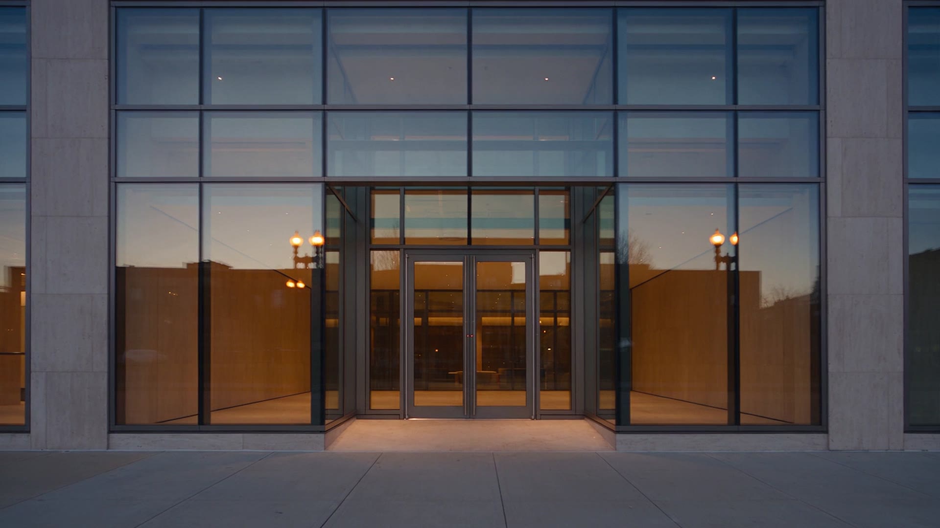 Modern glass storefront with slim black frames and a frameless entrance door